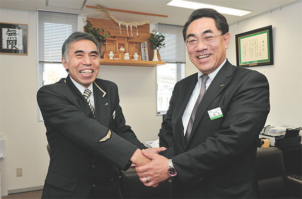 ▲中野駅・飯塚駅長といわき駅・川畑駅長。オリーブロードにかけた熱い思いでガッチリ握手